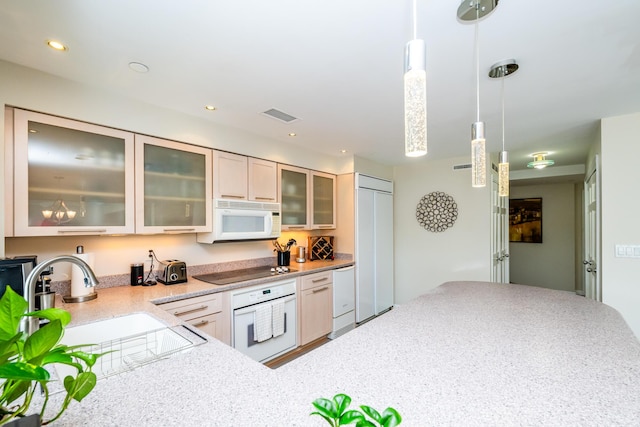 240 Water St Unit 1A, Saint Joseph, MI 49085 - kitchen featuring white appliances, a sink, hanging light fixtures, light stone countertops, and glass insert cabinets
