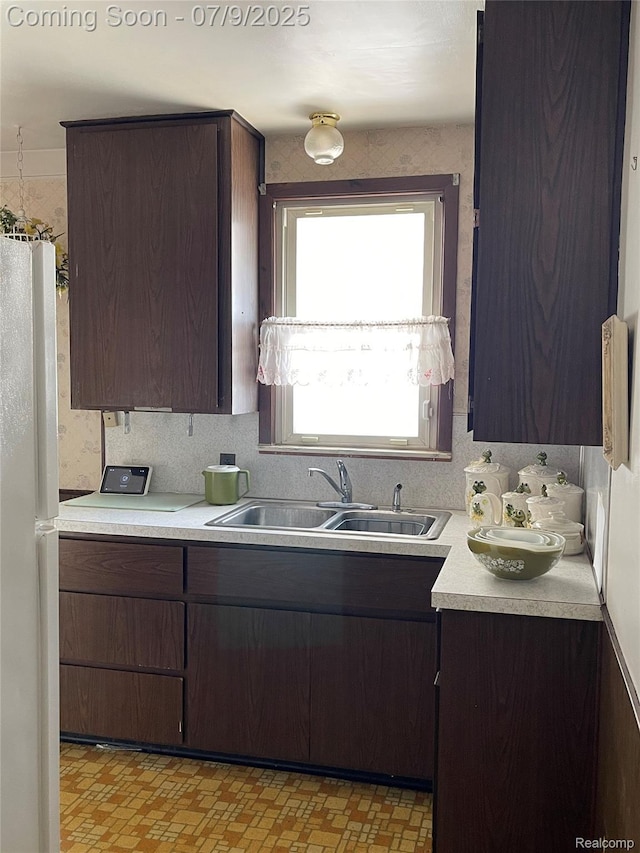 6250 Grandville Ave, Detroit, MI 48228 - kitchen featuring freestanding refrigerator, light countertops, and dark brown cabinetry