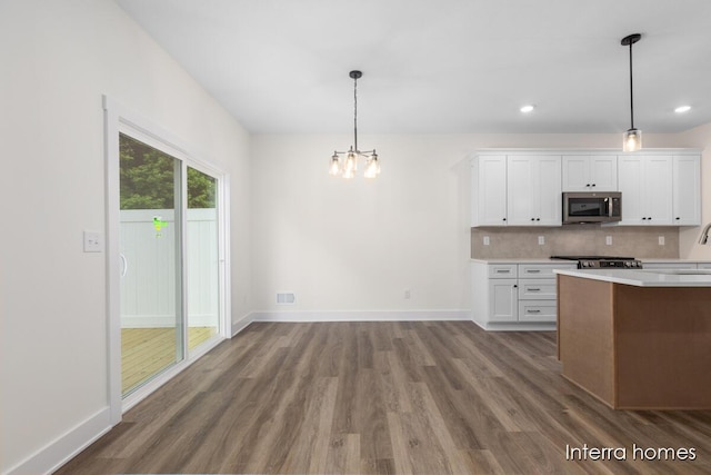 3343 Kings River St SW Unit 39, Wyoming, MI 49418 - kitchen featuring stainless steel microwave, light countertops, dark wood-style floors, a chandelier, and white cabinetry