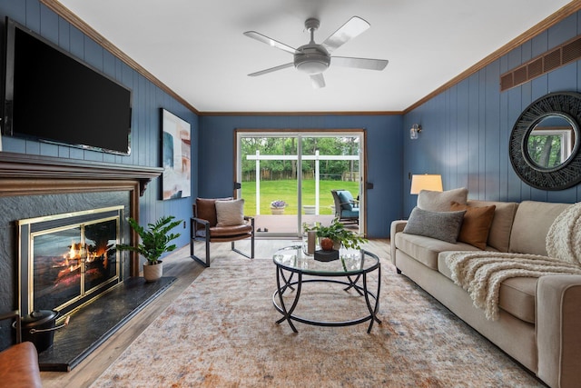 3673 Pheasant Dr, Ann Arbor, MI 48103 - living area with crown molding, wood finished floors, a ceiling fan, a premium fireplace, and wooden walls