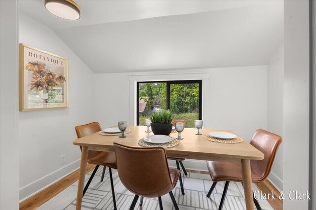 820 Hackett St, Ionia, MI 48846 - dining room featuring lofted ceiling, light wood-style floors, and baseboards
