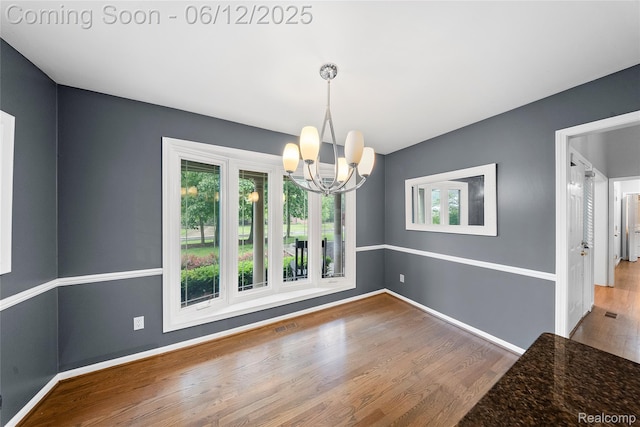 8487 Sherwood Dr, Grosse Ile, MI 48138 - unfurnished dining area featuring a chandelier, healthy amount of natural light, and wood finished floors