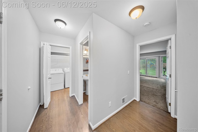 8487 Sherwood Dr, Grosse Ile, MI 48138 - corridor featuring washer and dryer, wood finished floors, and baseboards
