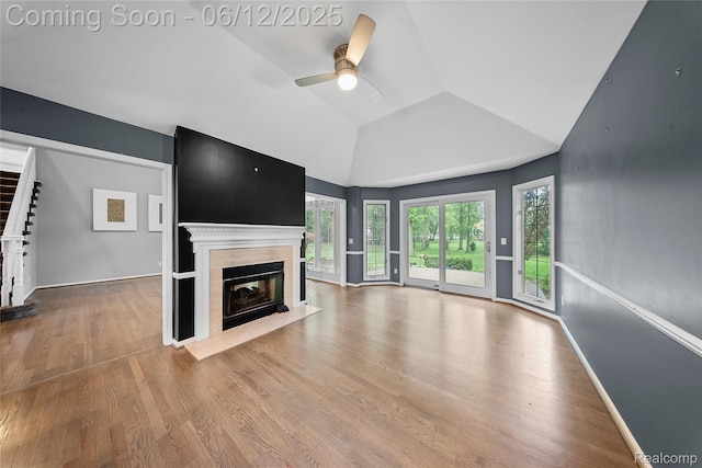 8487 Sherwood Dr, Grosse Ile, MI 48138 - unfurnished living room featuring a ceiling fan, wood finished floors, a fireplace with flush hearth, vaulted ceiling, and stairway