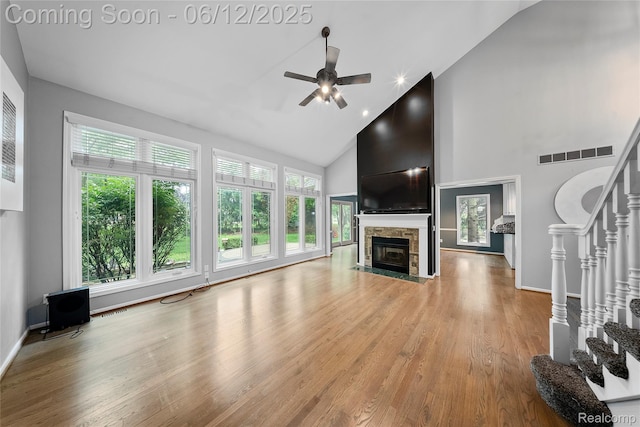 8487 Sherwood Dr, Grosse Ile, MI 48138 - unfurnished living room with stairway, high vaulted ceiling, a fireplace, ceiling fan, and light wood finished floors