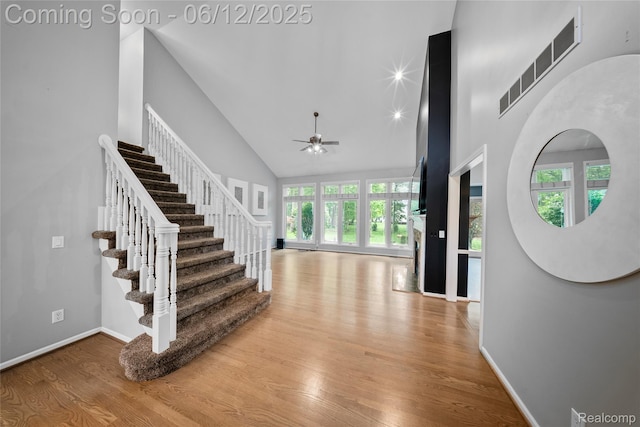 8487 Sherwood Dr, Grosse Ile, MI 48138 - entryway with wood finished floors, high vaulted ceiling, a ceiling fan, stairs, and baseboards
