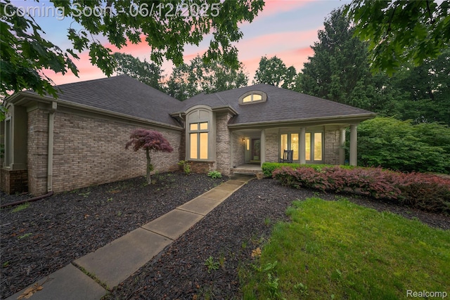8487 Sherwood Dr, Grosse Ile, MI 48138 - french country inspired facade featuring a porch, brick siding, and a shingled roof