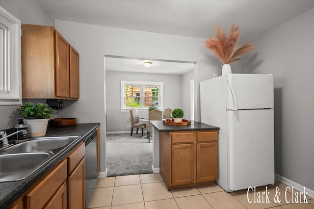 1714 Kalamazoo Ave SE, Grand Rapids, MI 49507 - kitchen with freestanding refrigerator, brown cabinets, a sink, and dark countertops