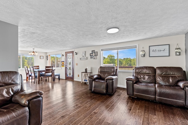 5886 13 Mile Rd, Remus, MI 49340 - living room with a chandelier, dark wood-type flooring, a textured ceiling, plenty of natural light, and baseboards