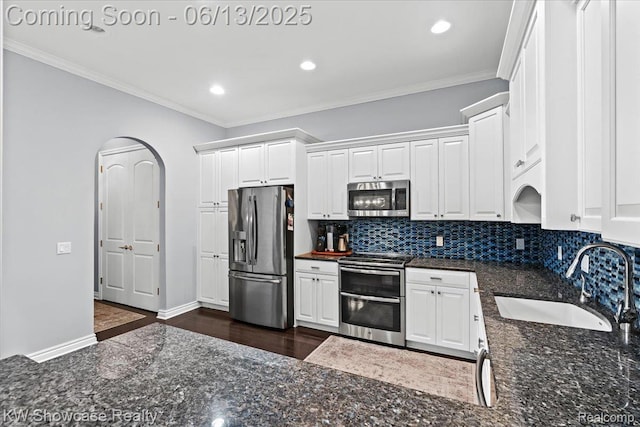 5624 Knob Hill Cir, Clarkston, MI 48348 - kitchen with appliances with stainless steel finishes, white cabinetry, decorative backsplash, dark wood-style flooring, and crown molding