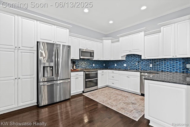 5624 Knob Hill Cir, Clarkston, MI 48348 - kitchen featuring appliances with stainless steel finishes, dark wood finished floors, white cabinets, ornamental molding, and backsplash