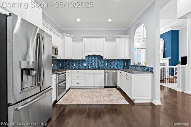 5624 Knob Hill Cir, Clarkston, MI 48348 - kitchen featuring appliances with stainless steel finishes, dark countertops, dark wood-style flooring, crown molding, and white cabinets