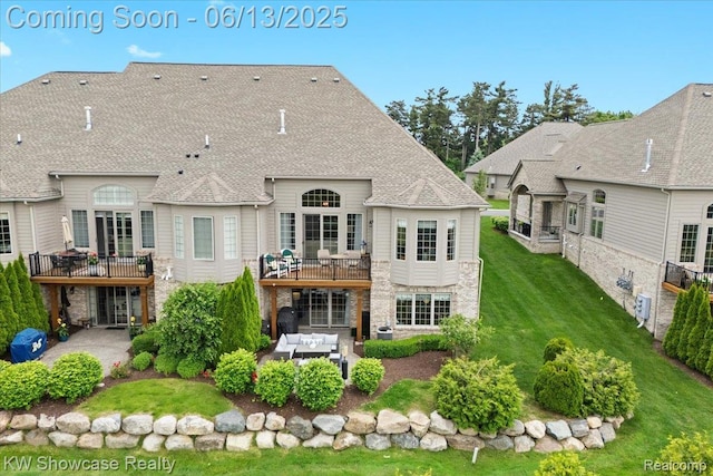 5624 Knob Hill Cir, Clarkston, MI 48348 - rear view of house with a patio area, outdoor lounge area, a yard, stone siding, and a wooden deck