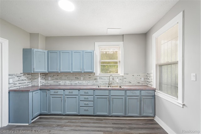 3054 Cadillac Blvd, Redford, MI 48214 - kitchen with a sink, blue cabinets, dark wood-style floors, tasteful backsplash, and a textured ceiling