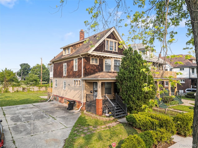 3054 Cadillac Blvd, Redford, MI 48214 - view of front facade with a chimney, a porch, concrete driveway, a front lawn, and stairway