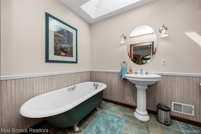 1982 E Coon Lake Rd, Howell, MI 48843 - full bath with a skylight, a wainscoted wall, and a freestanding tub