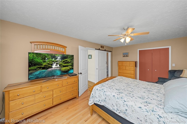 1982 E Coon Lake Rd, Howell, MI 48843 - bedroom with light wood-style flooring, ceiling fan, a closet, and a textured ceiling
