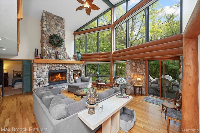 1982 E Coon Lake Rd, Howell, MI 48843 - living area with high vaulted ceiling, ceiling fan, a fireplace, wood finished floors, and healthy amount of natural light