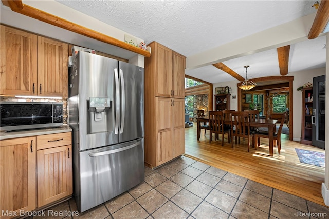 1982 E Coon Lake Rd, Howell, MI 48843 - kitchen featuring stainless steel appliances, beam ceiling, light tile patterned floors, hanging light fixtures, and decorative backsplash