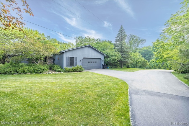 1982 E Coon Lake Rd, Howell, MI 48843 - view of side of property featuring a yard, asphalt driveway, and a garage