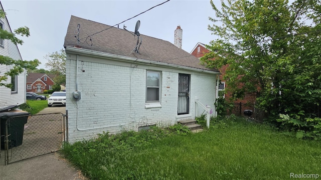 19610 Westphalia St, Detroit, MI 48205 - back of property with entry steps, brick siding, a chimney, and a shingled roof