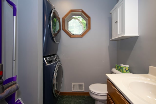 10926 Gorsline Rd, Battle Creek, MI 49014 - bathroom featuring stacked washer and clothes dryer, toilet, vanity, and baseboards