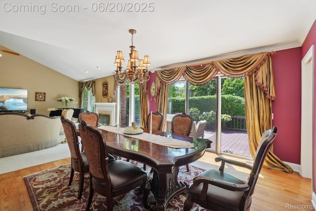 4541 Rivers Edge, Troy, MI 48098 - dining room featuring light wood finished floors, a chandelier, lofted ceiling, and a glass covered fireplace