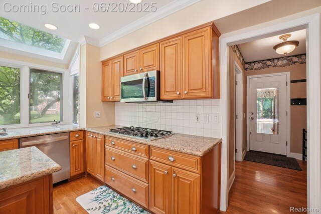 4541 Rivers Edge, Troy, MI 48098 - kitchen with stainless steel appliances, light wood-style flooring, ornamental molding, light stone counters, and healthy amount of natural light