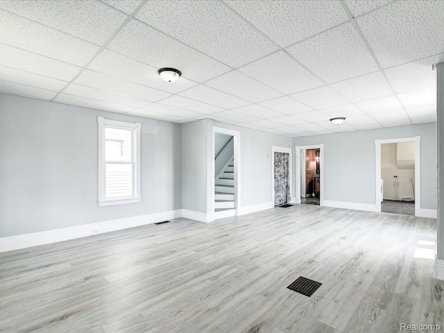 718 Superior St, Port Huron, MI 48060 - unfurnished living room with stairway, wood finished floors, a drop ceiling, and baseboards