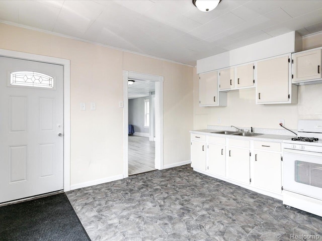 718 Superior St, Port Huron, MI 48060 - kitchen with white gas stove, a sink, light countertops, crown molding, and baseboards