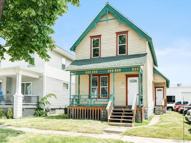 718 Superior St, Port Huron, MI 48060 - view of front of house featuring covered porch, a shingled roof, and a front lawn