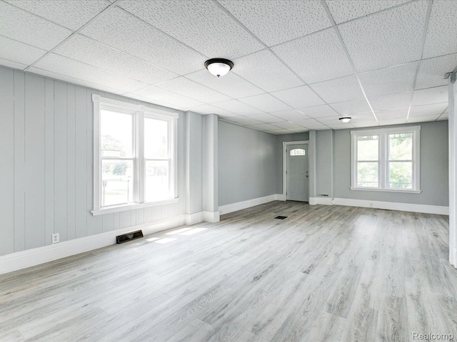 718 Superior St, Port Huron, MI 48060 - unfurnished living room with a paneled ceiling, wood finished floors, and baseboards