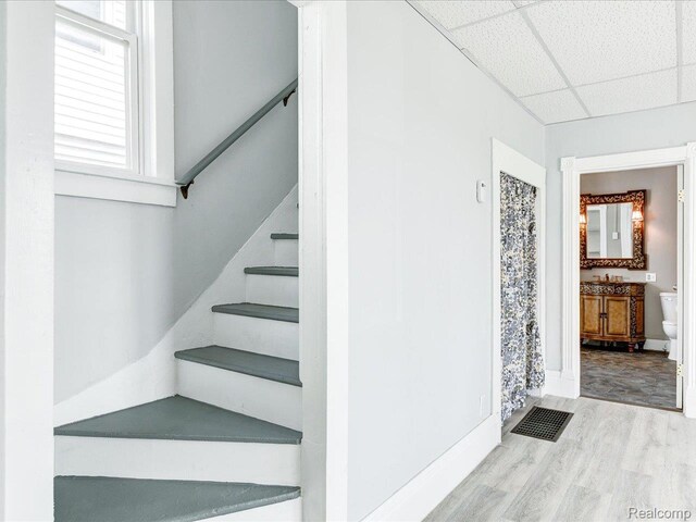 718 Superior St, Port Huron, MI 48060 - staircase featuring wood finished floors, a drop ceiling, and baseboards