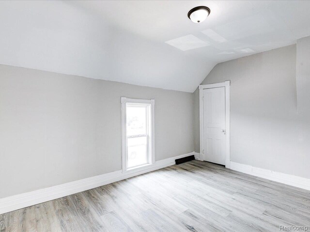 718 Superior St, Port Huron, MI 48060 - additional living space featuring lofted ceiling, wood finished floors, and baseboards