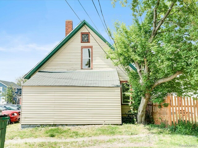 718 Superior St, Port Huron, MI 48060 - view of property exterior featuring a chimney, roof with shingles, and a barn