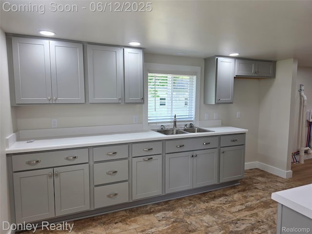 4514 Sebewaing Rd, Owendale, MI 48754 - kitchen with gray cabinets, a sink, baseboards, light countertops, and recessed lighting
