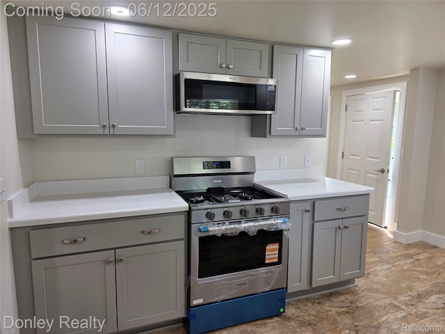 4514 Sebewaing Rd, Owendale, MI 48754 - kitchen with appliances with stainless steel finishes, gray cabinetry, light countertops, baseboards, and stone finish floors