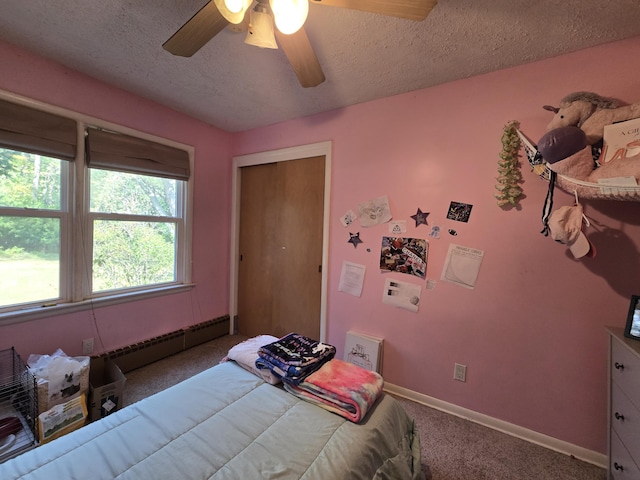 10017 M-115, Cadillac, MI 49601 - bedroom featuring carpet flooring, a baseboard radiator, a textured ceiling, baseboards, and ceiling fan