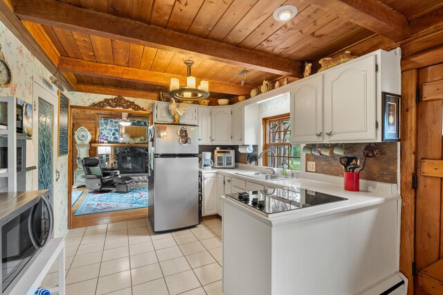 987 Wagner Dr, Battle Creek, MI 49017 - kitchen featuring appliances with stainless steel finishes, a sink, wooden ceiling with exposed beams, white cabinets, and light tile patterned floors