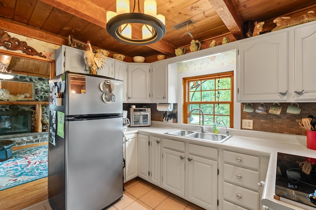 987 Wagner Dr, Battle Creek, MI 49017 - kitchen featuring freestanding refrigerator, wood ceiling with exposed beams, a sink, range, and decorative backsplash