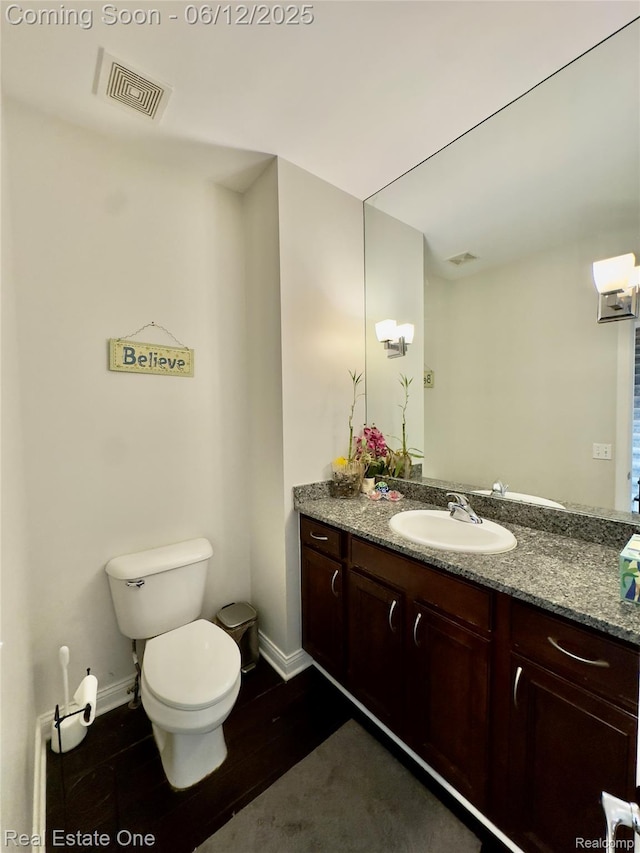 6038 Mayapple Dr, Troy, MI 48085 - half bathroom with toilet, vanity, baseboards, and wood finished floors