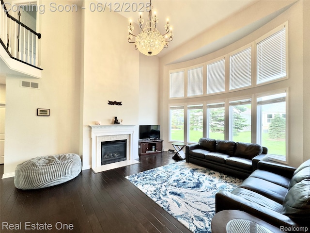 6038 Mayapple Dr, Troy, MI 48085 - living room with a towering ceiling, a chandelier, dark wood-style floors, a fireplace with flush hearth, and baseboards