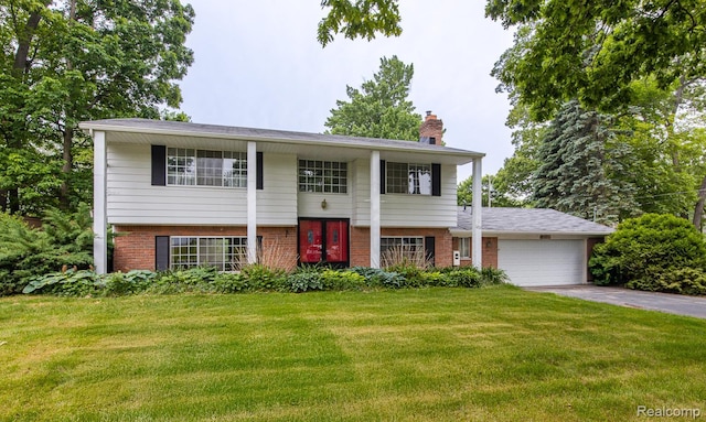 1231 Duckwood Ct, White Lake, MI 48383 - view of front of house featuring brick siding, a chimney, a front yard, and a garage