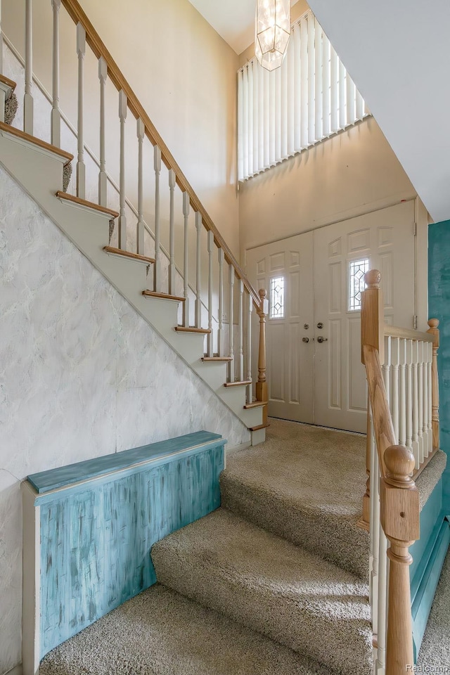 1231 Duckwood Ct, White Lake, MI 48383 - carpeted foyer with stairs, a towering ceiling, and a chandelier