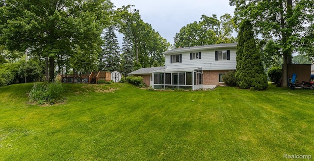 1231 Duckwood Ct, White Lake, MI 48383 - back of property featuring a storage shed, a sunroom, brick siding, and a yard