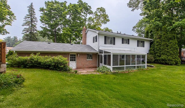 1231 Duckwood Ct, White Lake, MI 48383 - back of property featuring a sunroom, a lawn, and a chimney