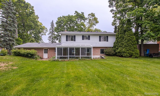 1231 Duckwood Ct, White Lake, MI 48383 - back of house with a sunroom, brick siding, and a yard