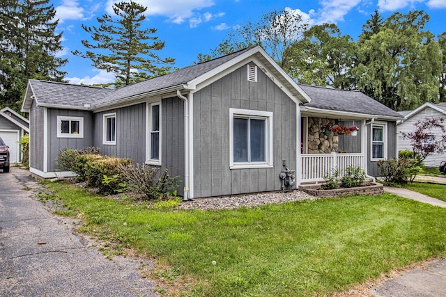 512 Clark St, Big Rapids, MI 49307 - ranch-style home with a front yard, covered porch, an outbuilding, and a shingled roof