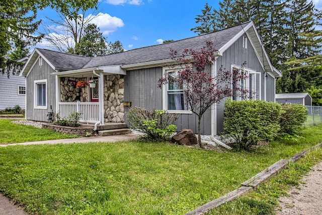 512 Clark St, Big Rapids, MI 49307 - view of front of home with covered porch, a front yard, and roof with shingles