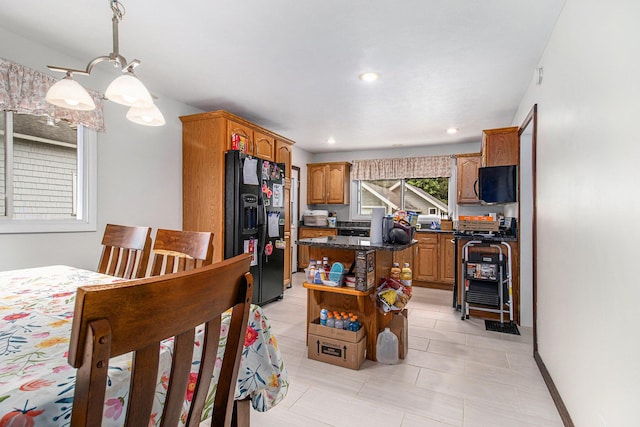 512 Clark St, Big Rapids, MI 49307 - kitchen with black fridge with ice dispenser, a center island, stove, brown cabinetry, and light tile patterned floors
